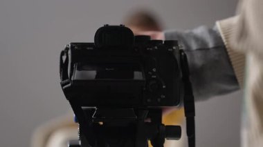 Kameramanın stüdyoda uzman bir video kaydetmek için kamerayı kurduğu sahne arkası. Bir kadın blogcu video blogunu kaydeder veya aboneleri için canlı yayın yapar.