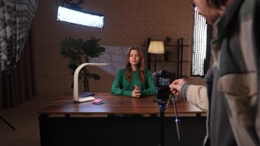 Kameramanın stüdyoda uzman bir video kaydetmek için kamerayı kurduğu sahne arkası. Bir kadın blogcu video blogunu kaydeder veya aboneleri için canlı yayın yapar.