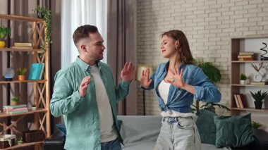 Hafta sonları birlikte birkaç boş zaman geçiririz. Çift evdeki kanepede dinleniyor, kadın ve erkek odada duruyor ve enerjik bir şekilde dans ediyor, gülümsüyor ve nazikçe dokunuyorlar. Yavaş çekim.