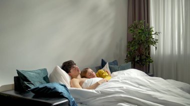 Hafta sonları birlikte birkaç boş zaman geçiririz. Çift yatak odasında birlikte dinleniyor, kadın ve erkek yatakta uzanıyor ve uyuyor, birbirlerine sarılıyorlar ve dinleniyorlar, mutlu bir ifade..