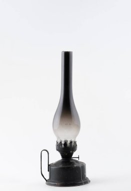 Beyaz arka planda is lekeli cam bacası olan klasik bir yağ lambası. Kırsal metal temeli ve sapı eski çekiciliğini arttırır..