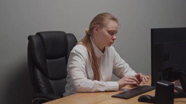 Ofiste çalışan genç bayan profesyonel yönetici. Yetişkin bir iş kadını ofiste bilgisayar başında oturuyor, baş ağrısı var, iyi hissetmiyor. Modern iş ve şirket kavramı.