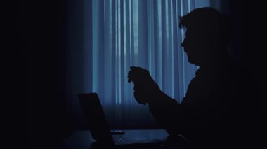 Loş bir odada para sayan bir kişinin silüeti. Yakınlardaki masanın üzerine bir bardak su konur..