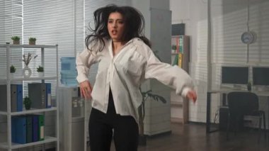 Yaratıcı iş konsepti. Genç iş kadını yönetici ofiste çalışıyor, profesyonel modern kadın dansçı ofis odasında koreografi elementleri sergiliyor. Yavaş çekim.