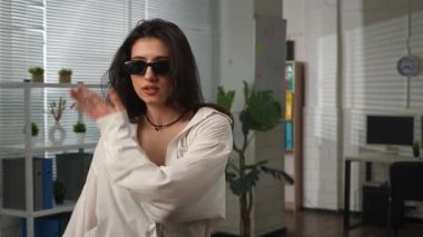 Yaratıcı iş konsepti. Genç iş kadını yönetici ofiste çalışıyor, profesyonel modern kadın dansçı ofis odasında koreografi elementleri sergiliyor. Yavaş çekim.