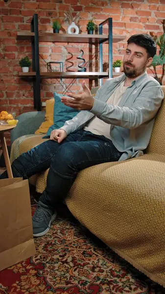 Abur cubur reklamı konsepti. Sakallı adam evde fast food dağıtımı ile vakit geçiriyor, kanepede oturuyor spor televizyon seyrediyor, takımı alkışlıyor ve kızarmış patates yiyor, hayal kırıklığına uğramış yüz ifadelerini tartışıyor..