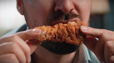 Abur cubur reklamı konsepti. Sakallı adamın, elinde tuttuğu ve tavuk budu çiğneyip ısırdığı, fast food 'un tadını çıkardığı yakın çekim. Yavaş çekim