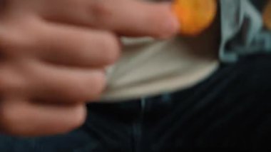 Abur cubur reklamı konsepti. Sakallı adamın kanepeye oturup, cam kaseden patates cipsi yiyip, fast food yediği yakın plan çekimler. Yavaş çekim