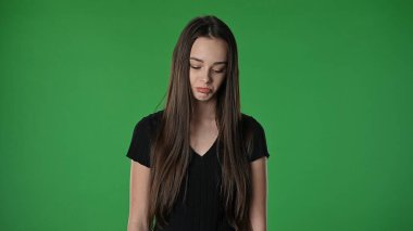 Gençlik duyguları konsepti. Kameraya poz veren genç kız üzgün surat, olumsuz ifade, krom anahtar yeşil ekran arka plan modelinde izole edilmiş..