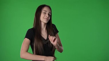 Gençlik duyguları konsepti. Kameraya poz veren genç kız gülümseyen ve dans eden komik dans eden, pozitif ifade, krom anahtar yeşil ekran arka plan modelinde izole edilmiş..