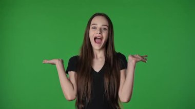 Gençlik duyguları konsepti. Genç kız, heyecan ve şaşkınlık içinde haykırıyor, gülümsüyor, pozitif ifade veriyor, krom anahtar yeşil ekran stüdyo arka planında izole edilmiş..
