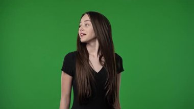 Gençlik duyguları konsepti. Genç kız kameraya bakıyor ve alkışlamaya başlıyor, gülümsüyor, pozitif ifade, krom anahtar yeşil ekranda izole edilmiş arka plan modeli..
