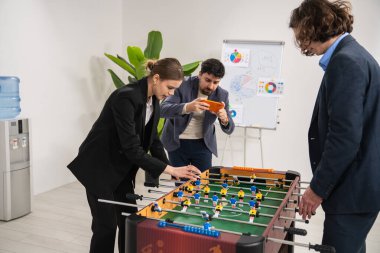 Takım ofisteki dostça langırt maçının keyfini çıkarıyor, iş molalarında takım ruhunu ve rahatlamayı teşvik ediyor..