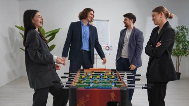 Modern bir ofisteki bir grup meslektaş hareketli bir langırt oyunu oynuyorlar, arkadaşlığı ve takım çalışmasını teşvik ediyorlar..