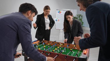 İş arkadaşlarının langırt oynadığı, takım çalışması ve dostluk sergilediği dinamik bir ofis..