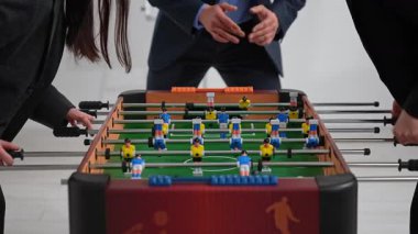 İş arkadaşları ofiste canlı bir langırt maçı düzenliyor, takım çalışması ve rekabetçi ruhlar sergiliyorlar. Kapat.