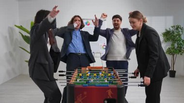 İş arkadaşlarının langırt zaferini kutladığı, takım çalışmasını ve iş yerinde eğlenceyi ön plana çıkardığı canlı bir ofis sahnesi..