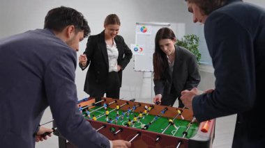 İş kıyafetleri giymiş bir grup iş arkadaşı langırt maçının keyfini çıkarıyorlar ve mola sırasında takım ruhunu geliştiriyorlar..