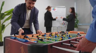 Takım üyelerinin masa futbolu oynayarak, takım çalışmasını ve işbirliğini teşvik ederek bağ kurdukları bir ofis ortamı.