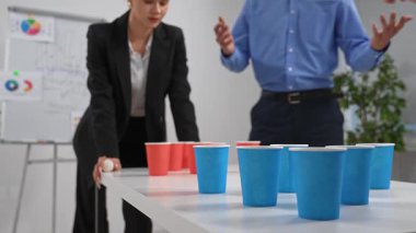 İş arkadaşlarının bardak kullanarak takım oluşturma oyunu oynadığı bir ofis ortamı. Stres atarken takım çalışmasını ve işbirliğini geliştirir. Kapat.