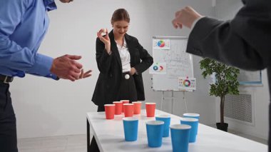 Takım üyeleri masa tenisi topları ve renkli bardaklarla eğlenceli bir ofis ilişkisi kurar, takım çalışmasını teşvik ederler..