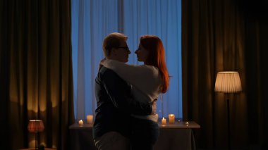 Çift sıcak bir mum ışığında sarılıp dans ediyor ve dans ediyor. Gece vakti romantik atmosfer mükemmel bir şekilde yakalanır..