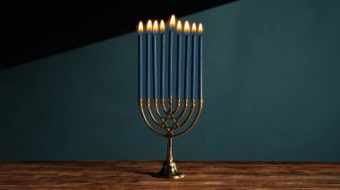 Tatil masasının sıcak atmosferinde yanan mavi mumları olan antika bir menorah bulunur. Bu masa, Hanuka 'nın ruhunu ve geleneklerini temsil ediyor..