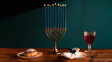 Hanukkah sırasında, mumlar güzel bir menorah, sufganiyah, bir bardak kırmızı şarap ve servis tabağıyla tatil masasını aydınlatır. Bayramın kültürel gelenekleri ve ruhaniliği.