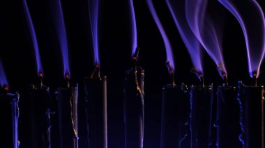 Menoranın içinde sönmüş dokuz mavi mum var. Mumlardan gri duman çıkıyor. Hanuka 'nın şenlikli atmosferi, bu kutsal bayrama olan inancı ve geleneği simgeliyor..