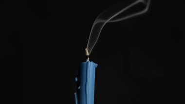 Bir sönmüş mavi mum. Mumdan gri duman çıkıyor. Dini bayramın geleneğini ve inancını simgeleyen şenlikli bir atmosfer. Anma günü..