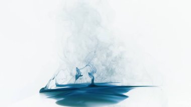 Suda zarifçe dönen büyüleyici mavi mürekkep görüntüsü beyaz arka plana karşı sanatsal ve hassas desenler yaratıyor..