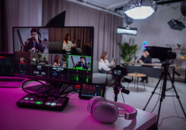 Canlı seanslar için mikser, monitör ve kameraların yer aldığı ileri düzey kayıt ayarlarıyla bir podcast stüdyosu..