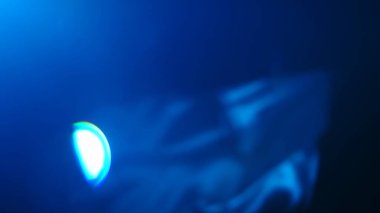 Mavi ışık gösteren soyut bir görüntü hareket bulanıklığı ve lens parlaklık efekti dinamik bir görsel etki yaratıyor..