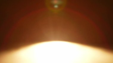 Sıcak tonlu soyut bulanık bir görüntü büyüleyici bir mercek alevi etkisi yaratarak rahatlatıcı bir atmosfer yayıyor. Yavaş çekim.