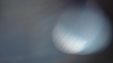 Bulanık, nötr bir arkaplanda yumuşak, gökkuşağı benzeri ışık desenleri içeren soyut bir kompozisyon. Yavaş çekim.