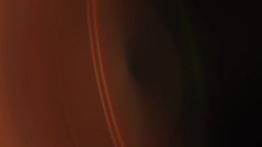 Sıcak tonlu soyut bulanık bir görüntü büyüleyici bir mercek alevi etkisi yaratarak rahatlatıcı bir atmosfer yayıyor. Yavaş çekim.