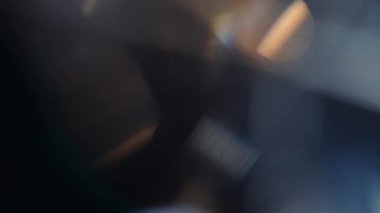 Karanlık bir ortamda parlayan ışık yansımaları ve bokeh efektlerinin soyut bir bileşimi gizemli ve atmosferik bir hava yaratıyor. Yavaş çekim.