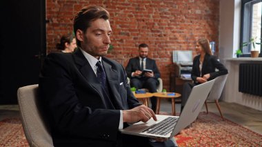 Modern bir ofis ortamında çalışan ve tartışan bir grup profesyonel, işbirliğini vurguladı.