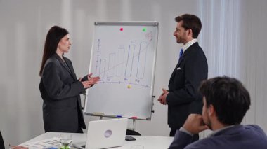 İş dünyasından profesyonellerden oluşan bir ekip, bir çalışma ortamında verileri analiz etmek ve stratejileri tartışmak üzere bir çalışma tablosunun etrafında toplandı. Yavaş çekim