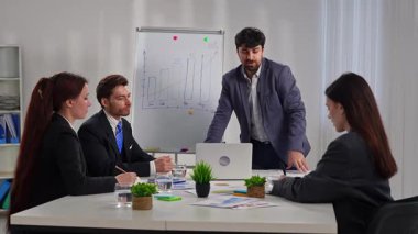 İş dünyasından profesyonellerden oluşan bir ekip, bir çalışma ortamında verileri analiz etmek ve stratejileri tartışmak üzere bir tablonun etrafında toplandı..