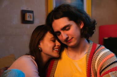 Genç bir çift sıcak, samimi bir anı paylaşır. Samimi bir ortamda sevgi ve yakınlığı yansıtır..