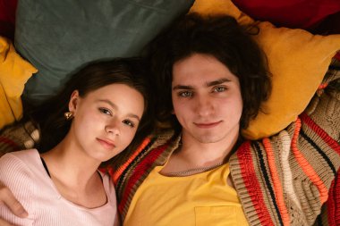 Genç bir çift sıcak, samimi bir anı paylaşır. Samimi bir ortamda sevgi ve yakınlığı yansıtır. Üst çekim