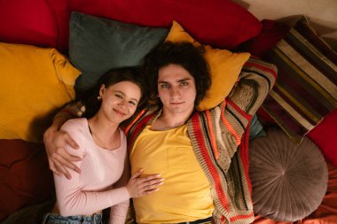 Genç bir çift sıcak, samimi bir anı paylaşır. Samimi bir ortamda sevgi ve yakınlığı yansıtır. Üst çekim