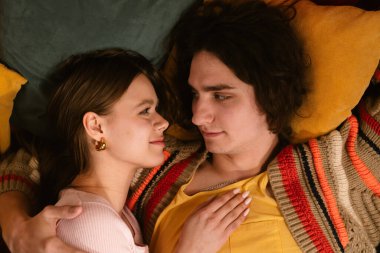 Genç bir çift sıcak, samimi bir anı paylaşır. Samimi bir ortamda sevgi ve yakınlığı yansıtır. Üst çekim