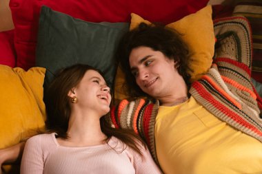 Genç bir çift sıcak, samimi bir anı paylaşır. Samimi bir ortamda sevgi ve yakınlığı yansıtır. Üst çekim