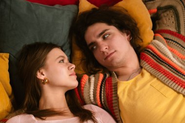 Genç bir çift sıcak, samimi bir anı paylaşır. Samimi bir ortamda sevgi ve yakınlığı yansıtır. Üst çekim