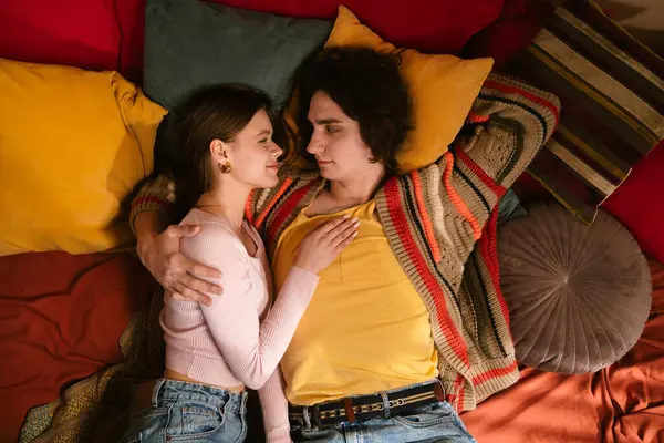 Genç bir çift sıcak, samimi bir anı paylaşır. Samimi bir ortamda sevgi ve yakınlığı yansıtır. Üst çekim