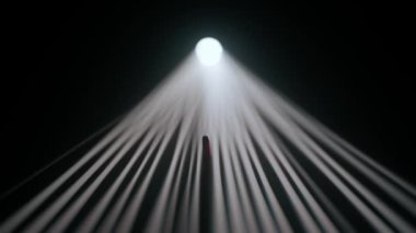 Sisli karanlık stüdyoda sahne ışıklarının içindeki kişi. Parlak beyaz spot ışıkları, karanlıkta parlayan profesyonel ışıklandırma ekipmanları, el silueti dumana ve ışık ışınlarına dokunarak oynuyor..