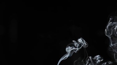 Karanlık bir zemin üzerinde dönen dumanın güzel bir bileşimi, ruhani ve geçici doğayı yakalıyor..