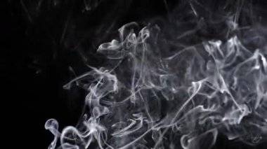 Dönen beyaz duman, karanlık bir zemin üzerinde karmaşık desenler oluşturur, akışkan hareketler ve ruhani güzellikler sergiler. Yavaş çekim